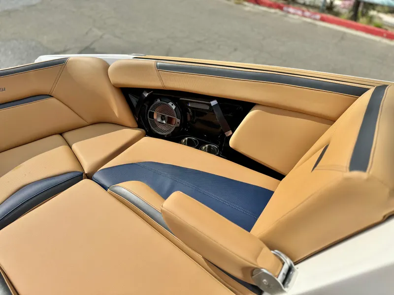 Slide: The Image of 2022 MasterCraft XStar interior with tan and blue seating, featuring premium audio system. - 18