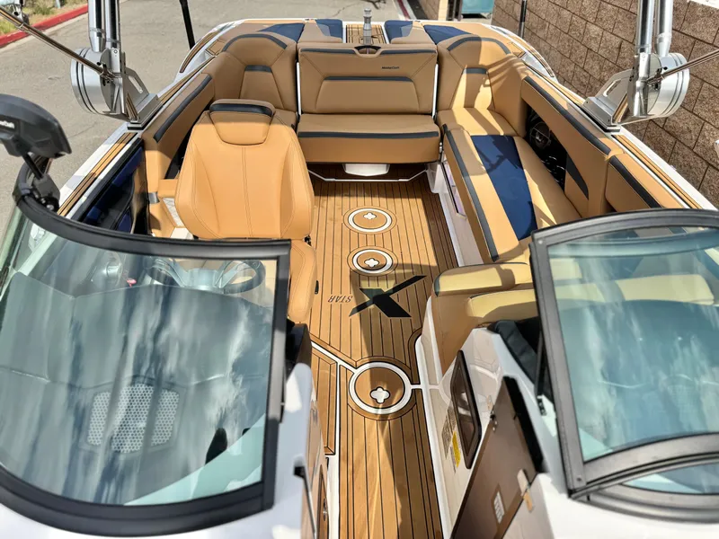 Slide: The Image of 2022 MasterCraft XStar boat interior with tan seating and teak flooring. - 19