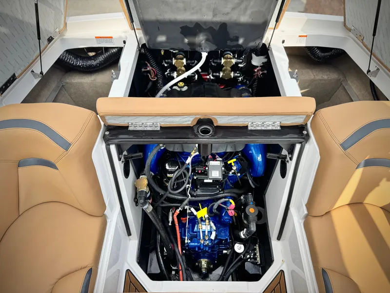 Slide: The Image of 2022 MasterCraft XStar engine compartment with tan seating and visible blue engine components. - 23