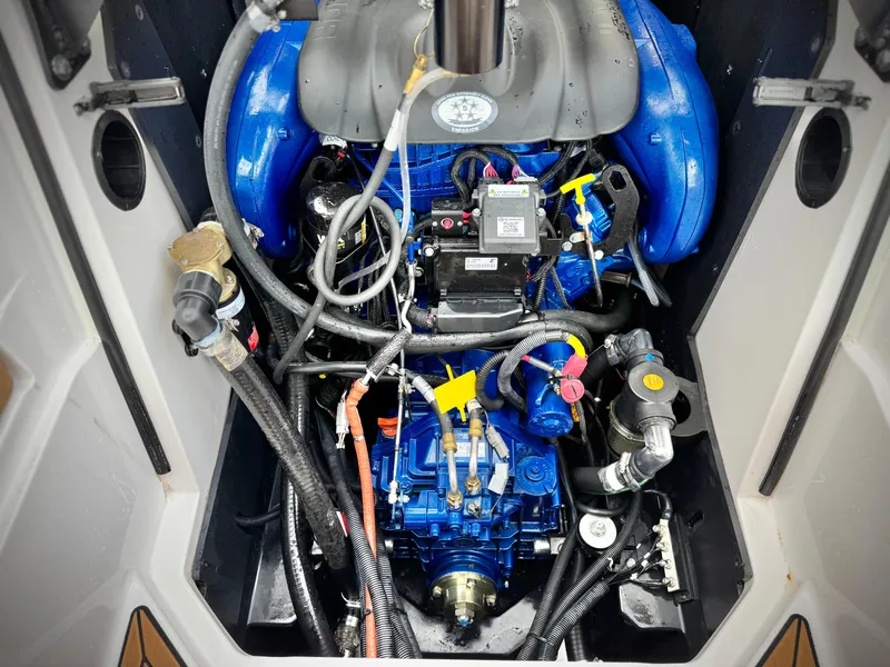 Slide: The Image of 2022 MasterCraft XStar engine compartment with blue components and intricate wiring. - 24