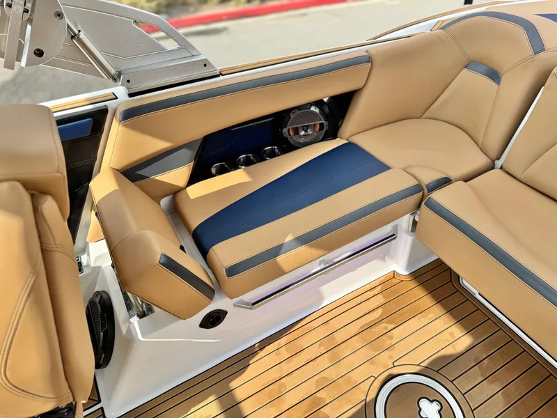 Slide: The Image of 2022 MasterCraft XStar interior with tan and blue seating, featuring sleek design and wood flooring. - 27