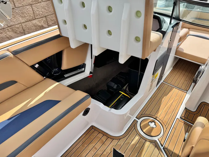 Slide: The Image of 2022 MasterCraft XStar boat interior with tan seating and open storage compartment. - 29