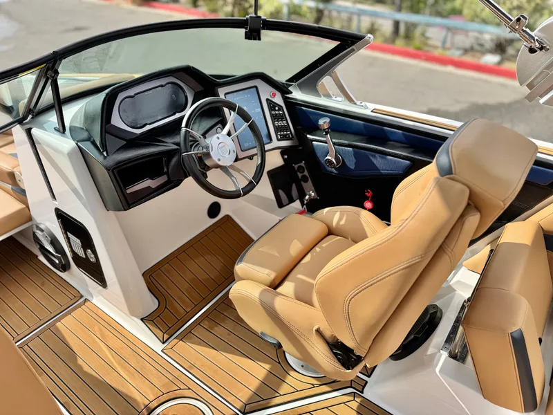 Slide: The Image of 2022 MasterCraft XStar boat interior with tan seats and modern dashboard. - 31