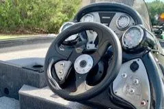 Slide: The Image of 2023 Tracker Pro Team 175 TXW boat dashboard with steering wheel and gauges. - 2