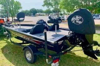 Slide: The Image of 2023 Tracker Pro Team 175 TXW fishing boat on grass, featuring a sleek design and motor cover. - 3