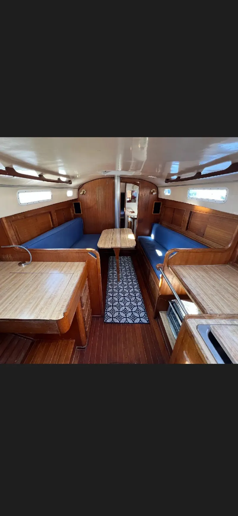 Slide: The Image of 1975 Bristol 34 yacht interior with wooden finish and blue seating. - 10