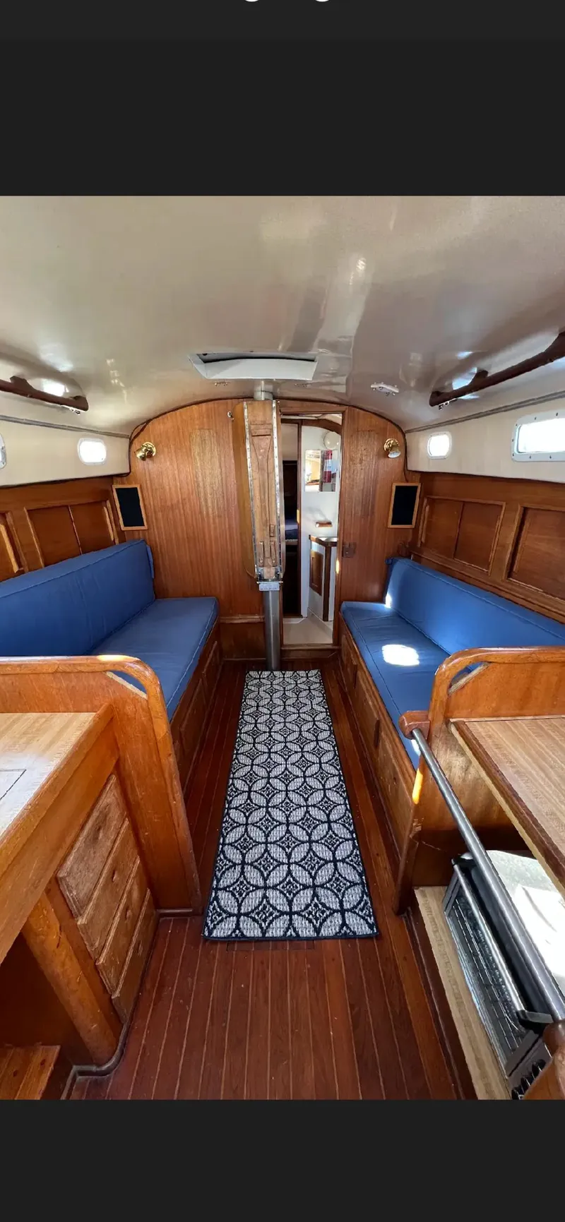 Slide: The Image of 1975 Bristol 34 yacht interior with wooden finish and blue seating. - 12