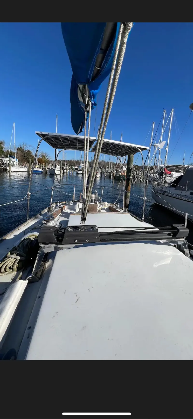 Slide: The Image of 1975 Bristol 34 sailboat docked in a marina under clear blue skies. - 4