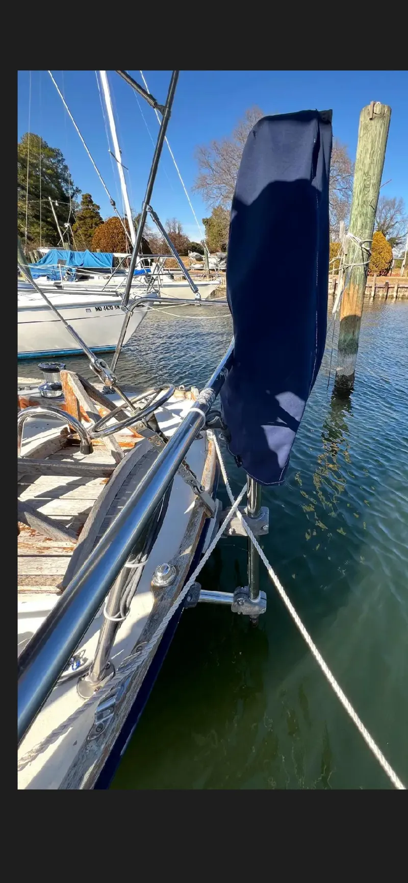 Slide: The Image of 1975 Bristol 34 sailboat docked, featuring polished railings and blue sail cover. - 7
