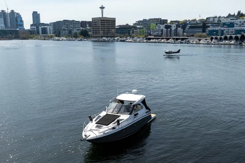 Slide: The Image of 2018 Regal 35 Sport Coupe on water with cityscape and seaplane in background. - 14