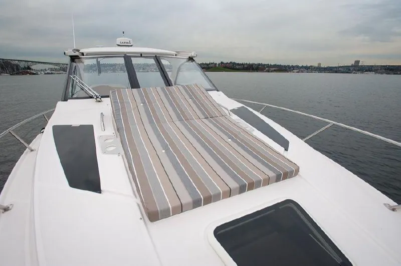 Slide: The Image of 2018 Regal 35 Sport Coupe yacht with striped sunbed on deck, cruising on calm waters. - 21