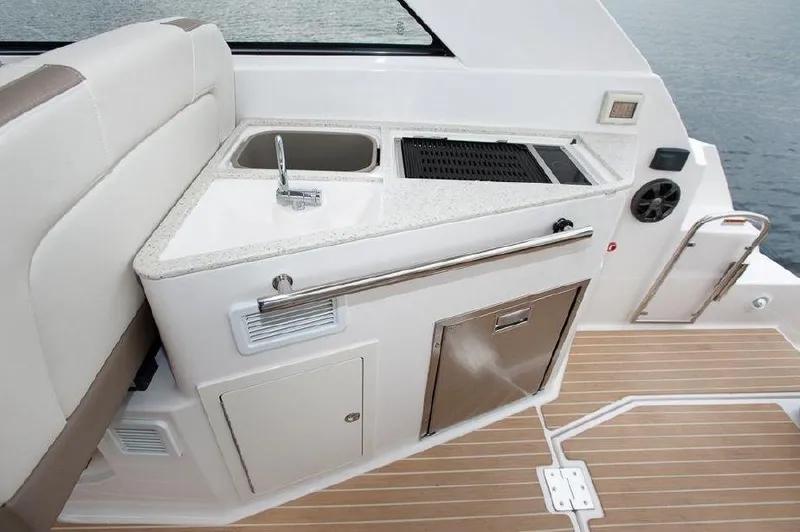 Slide: The Image of 2018 Regal 35 Sport Coupe boat kitchenette with sink and grill on deck. - 30