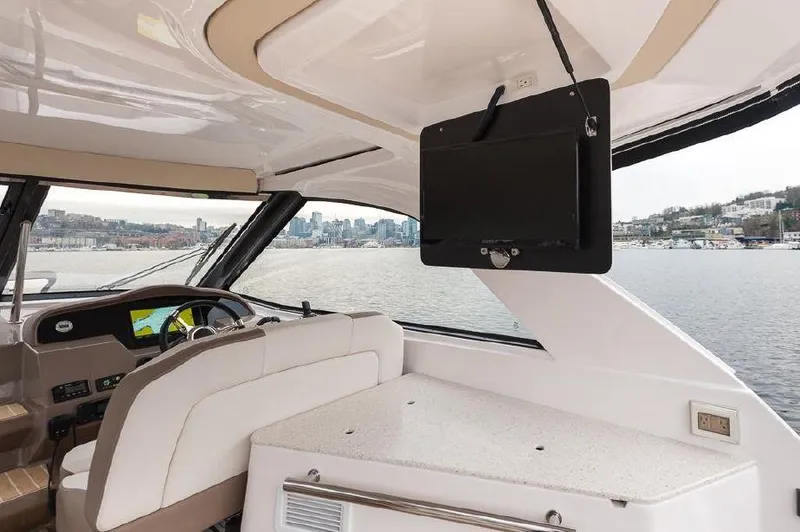 Slide: The Image of 2018 Regal 35 Sport Coupe interior with helm, TV, and waterfront view. - 31