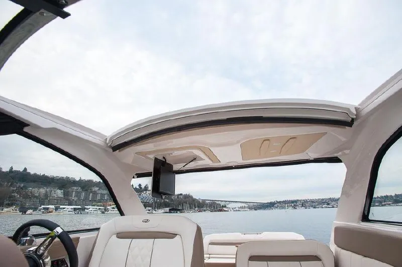 Slide: The Image of 2018 Regal 35 Sport Coupe interior with open sunroof, overlooking serene waters. - 33