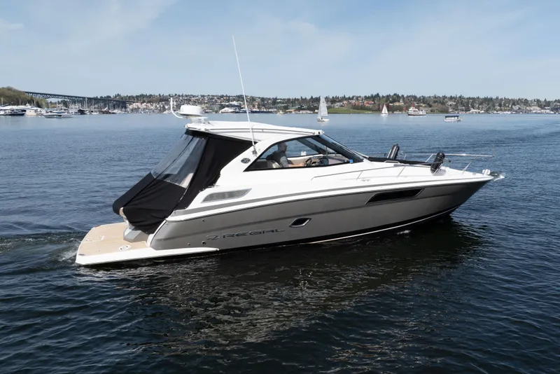 Slide: The Image of 2018 Regal 35 Sport Coupe cruising on a calm lake with scenic background. - 4