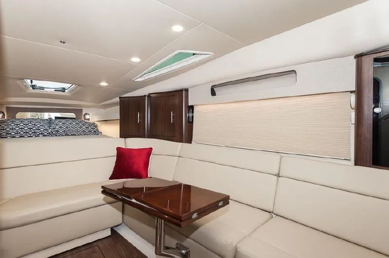 Slide: The Image of 2018 Regal 35 Sport Coupe interior with beige seating, wooden table, and red cushion. - 49