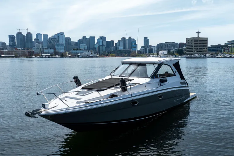 Slide: The Image of 2018 Regal 35 Sport Coupe yacht on water with city skyline backdrop. - 9