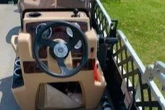 Slide: The Image of 2019 Sun Tracker BASS BUGGY 18 steering console with beige dashboard and black steering wheel. - 2