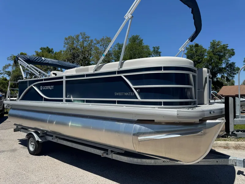 The Image of 2025 Sweetwater 2286 C pontoon boat on trailer, featuring sleek design and modern amenities. - 0