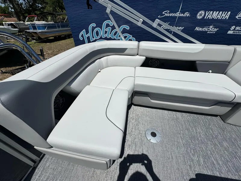 Slide: The Image of 2025 Sweetwater 2286 C boat interior with white cushioned seating and gray flooring. - 10