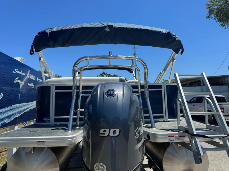 Slide: The Image of 2025 Sweetwater 2286 C pontoon boat with 90 HP engine, rear view, sunny day. - 15
