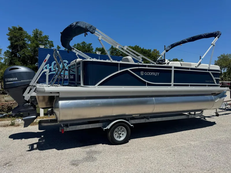 Slide: The Image of 2025 Sweetwater 2286 C pontoon boat on trailer, featuring Yamaha outboard motor. - 2