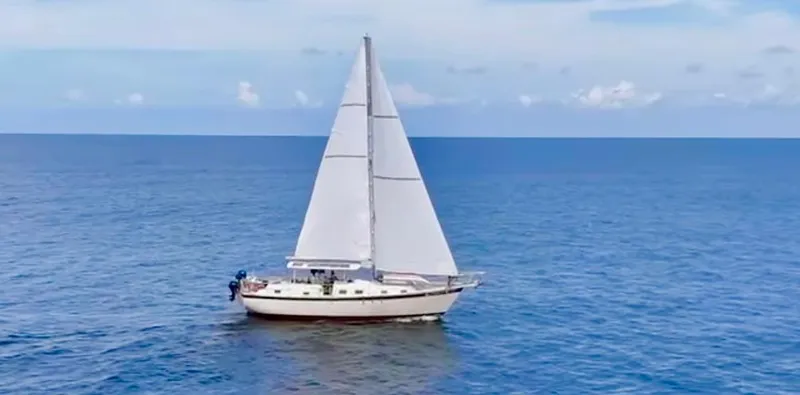 Slide: The Image of 1974 Irwin 37 sailboat cruising on open sea under clear skies. - 0