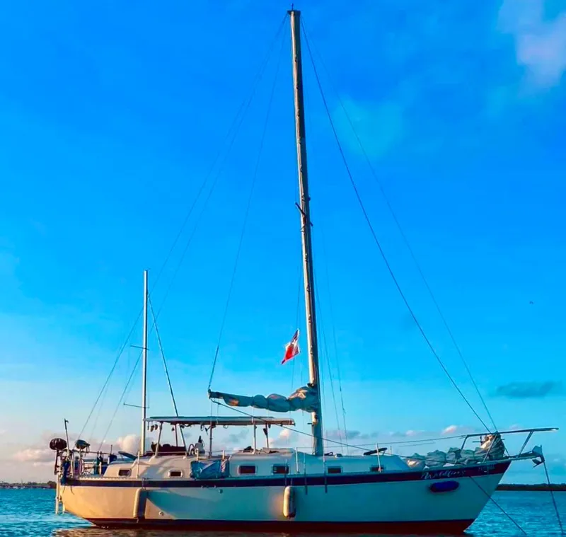 Slide: The Image of 1974 Irwin 37 sailboat on calm water under a clear blue sky. - 1