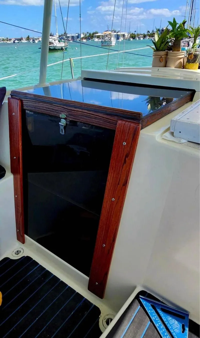 Slide: The Image of 1974 Irwin 37 sailboat cockpit with wooden hatch, docked by turquoise waters. - 14