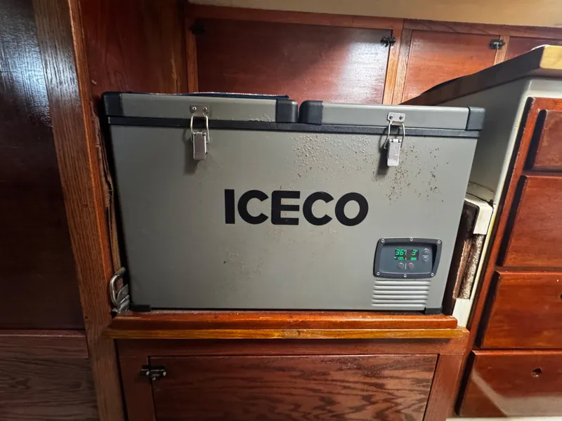 Slide: The Image of Portable ICECO cooler inside a 1974 Irwin 37 boat, secured with metal latches. - 17