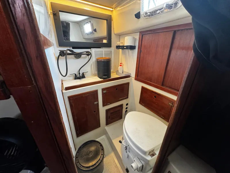 Slide: The Image of 1974 Irwin 37 sailboat bathroom with wooden cabinets and marine toilet. - 18