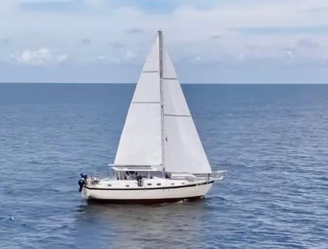 Slide: The Image of 1974 Irwin 37 sailboat cruising on open sea under clear skies. - 2