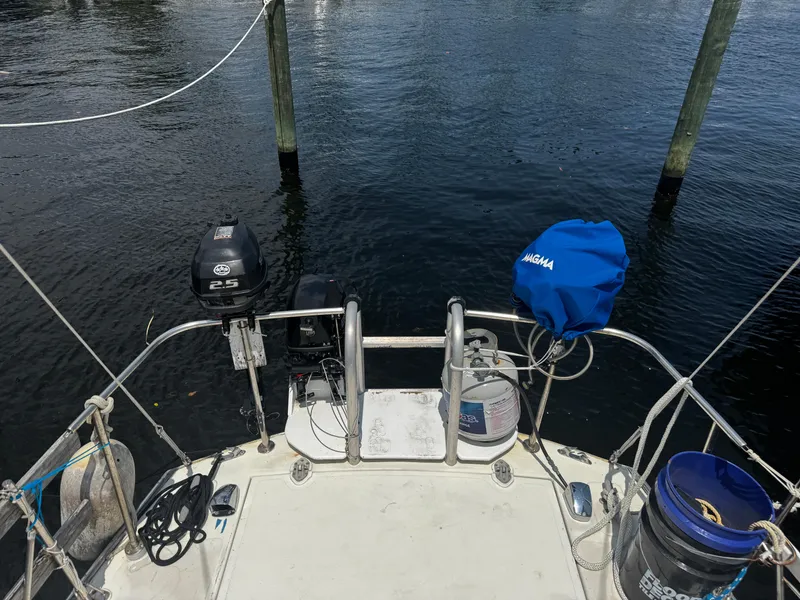 Slide: The Image of 1974 Irwin 37 sailboat stern view with outboard motor and docked at marina. - 26