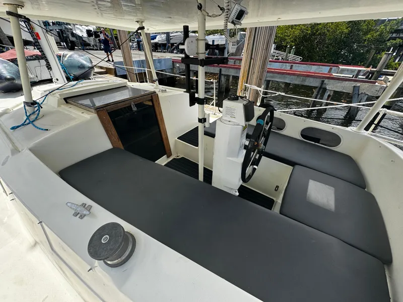 Slide: The Image of 1974 Irwin 37 sailboat cockpit with seating, steering wheel, and marina background. - 28