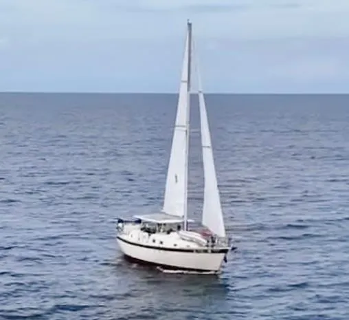Slide: The Image of 1974 Irwin 37 sailboat cruising on open sea under clear skies. - 3