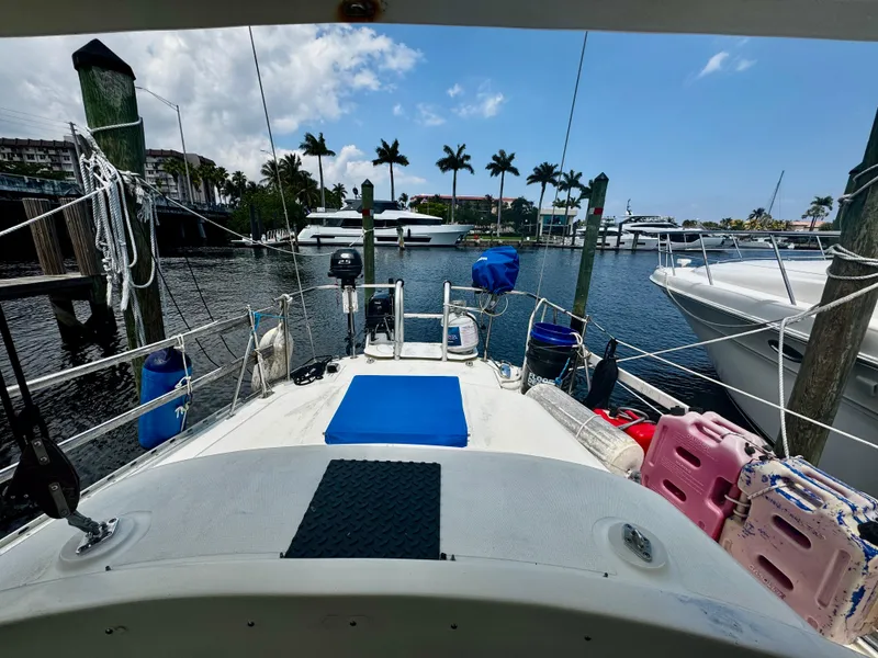 Slide: The Image of 1974 Irwin 37 sailboat docked at a marina with palm trees and clear skies. - 33