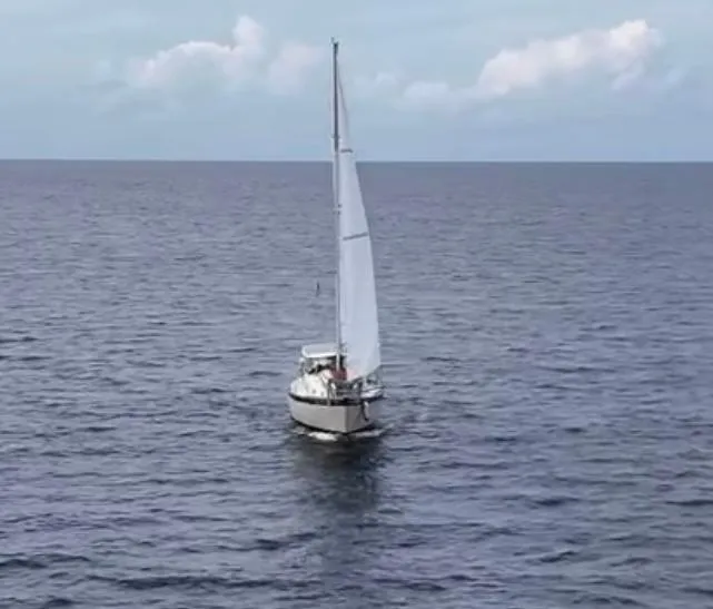 Slide: The Image of 1974 Irwin 37 sailboat navigating open sea under clear skies. - 45