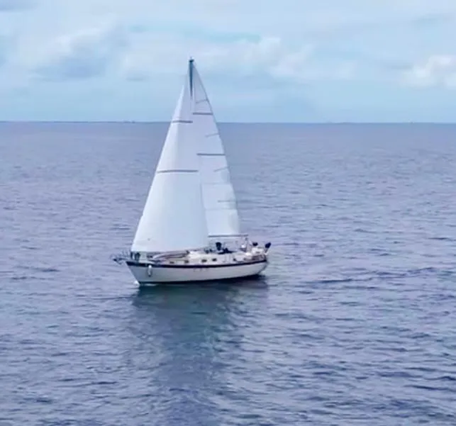 Slide: The Image of Sailboat on open sea, Irwin 37 model, 1974, with white sails against a blue sky. - 6