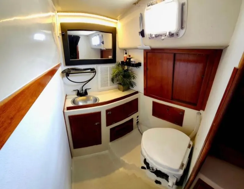 Slide: The Image of 1974 Irwin 37 yacht bathroom with wooden cabinets, sink, and toilet. - 7