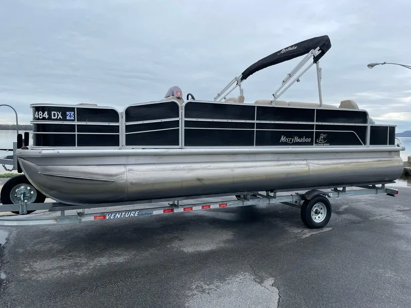 Slide: The Image of 2017 Misty Harbor 245 Adventure CC pontoon boat on trailer, side view. - 1