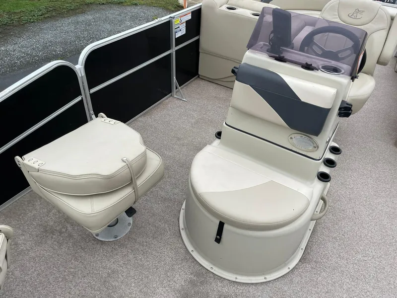 Slide: The Image of 2017 Misty Harbor 245 Adventure CC boat interior with beige seating and steering console. - 10