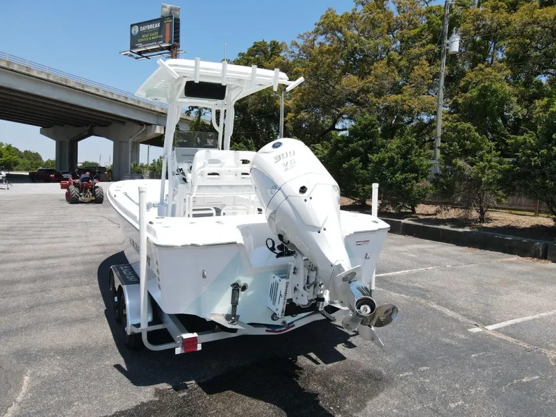 Slide: The Image of 2025 Blazer Bay 2440 boat with outboard motor in a parking lot. - 4