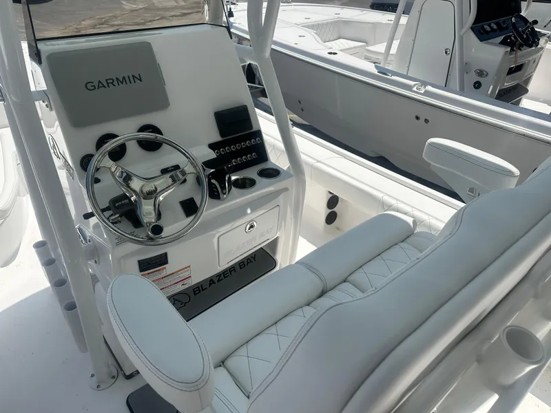 Slide: The Image of 2025 Blazer Bay 2440 boat cockpit with Garmin navigation and steering wheel. - 9