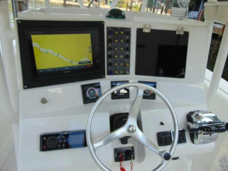 Slide: The Image of Control panel of a 2002 Jupiter 27 Open boat with navigation screen and steering wheel. - 11