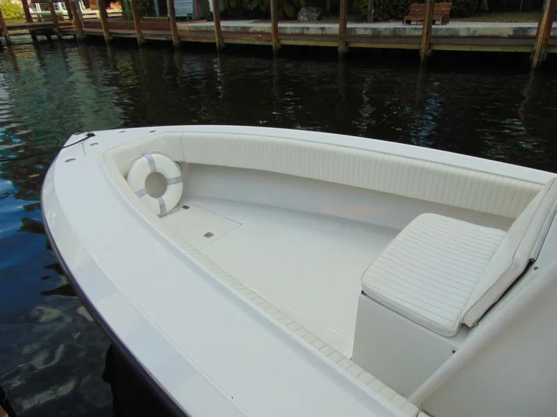 Slide: The Image of 2002 Jupiter 27 Open boat with white seating, docked by a wooden pier. - 5