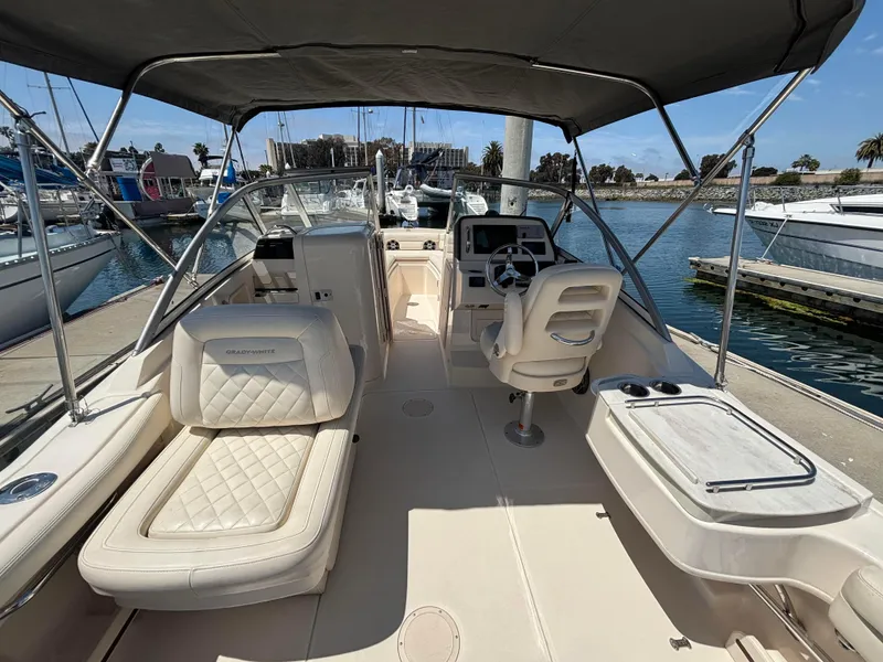 Slide: The Image of 2017 Grady-White Freedom 235 boat interior with seating and helm, docked at marina. - 13