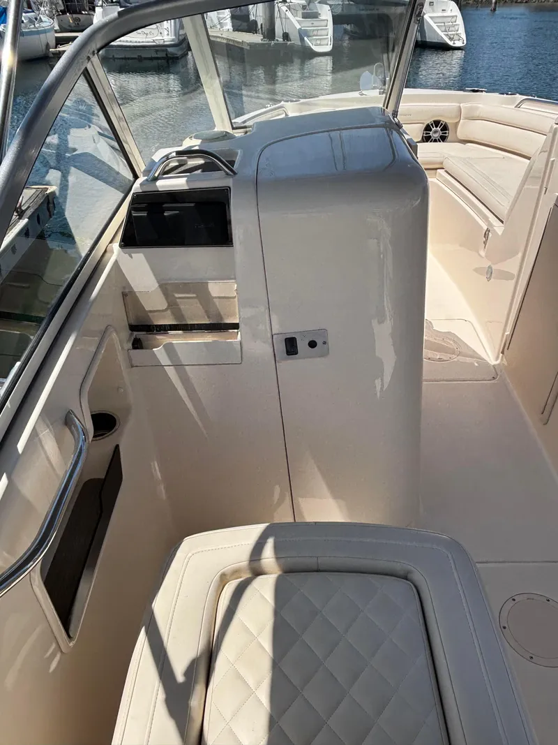 Slide: The Image of 2017 Grady-White Freedom 235 boat interior with seating and helm, docked at marina. - 14