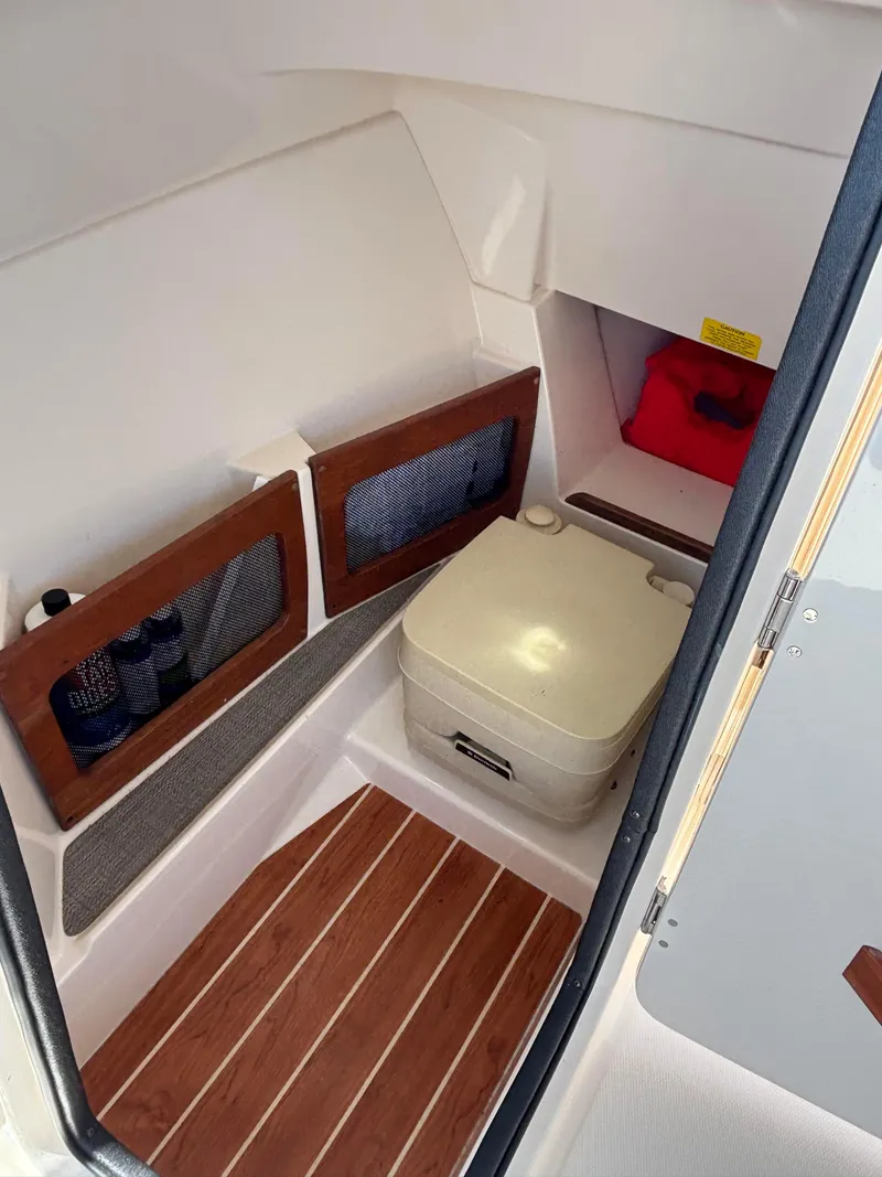 Slide: The Image of 2017 Grady-White Freedom 235 boat interior with portable toilet and storage compartments. - 19