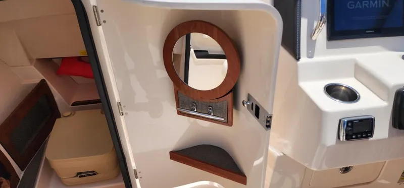 Slide: The Image of 2017 Grady-White Freedom 235 boat interior with mirror, storage, and Garmin display. - 20