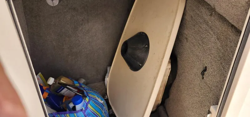 Slide: The Image of Storage compartment in a 2017 Grady-White Freedom 235 boat with supplies and a table. - 21